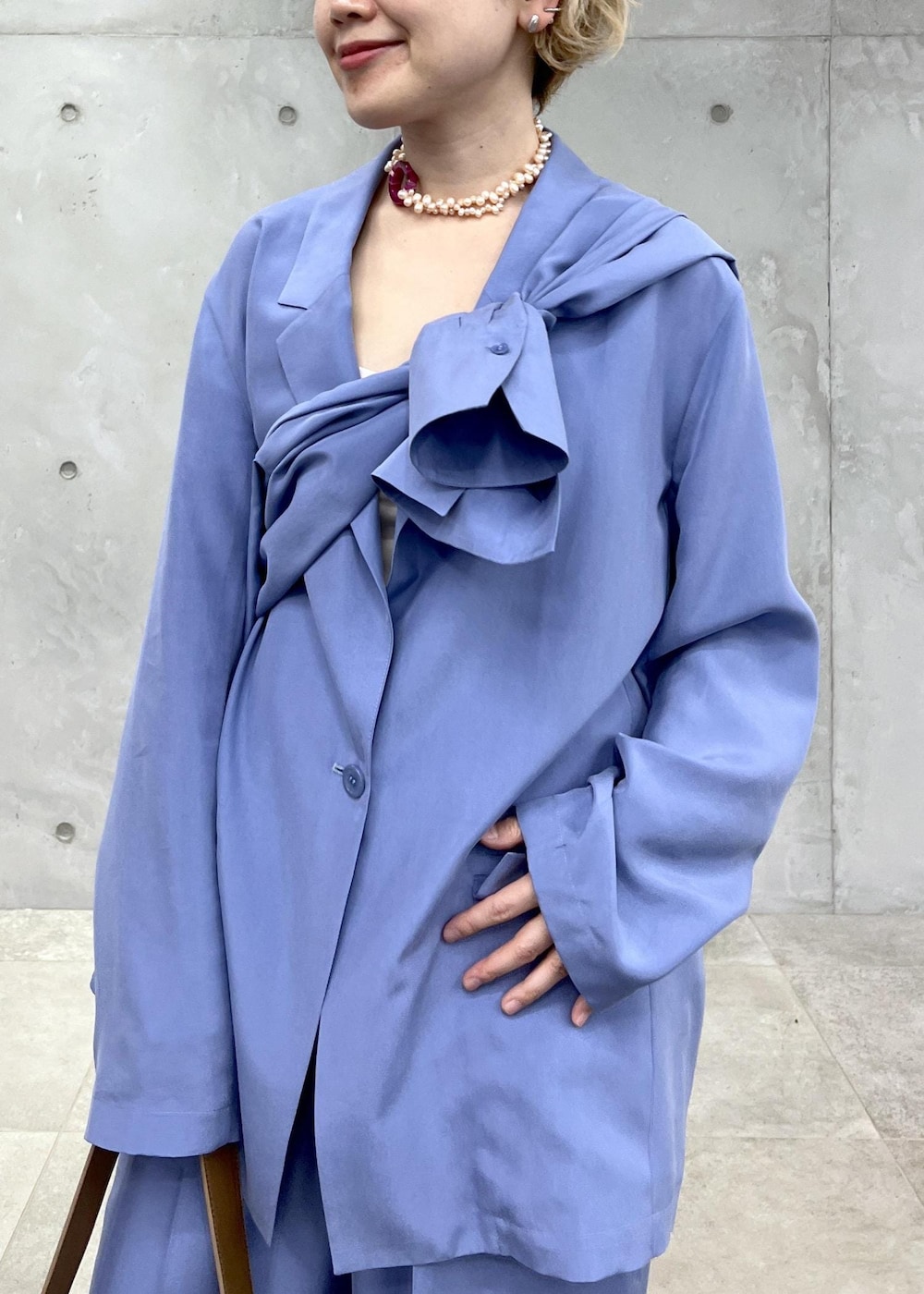 ブラウン系のショルダーバッグ、ブラウン系のサンダル、ブルー系のテーラードジャケットを着用したレディースの冬コーディネートの5枚目の写真