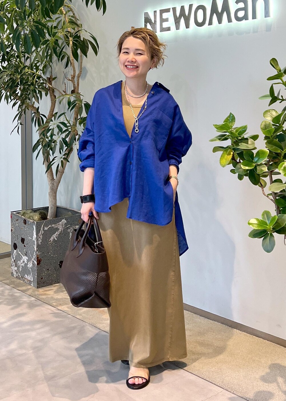 ブルー系のシャツ/ブラウス、ブラウン系のトートバッグ、ブラウン系のワンピースを着用したレディースの夏コーディネートの2枚目の写真