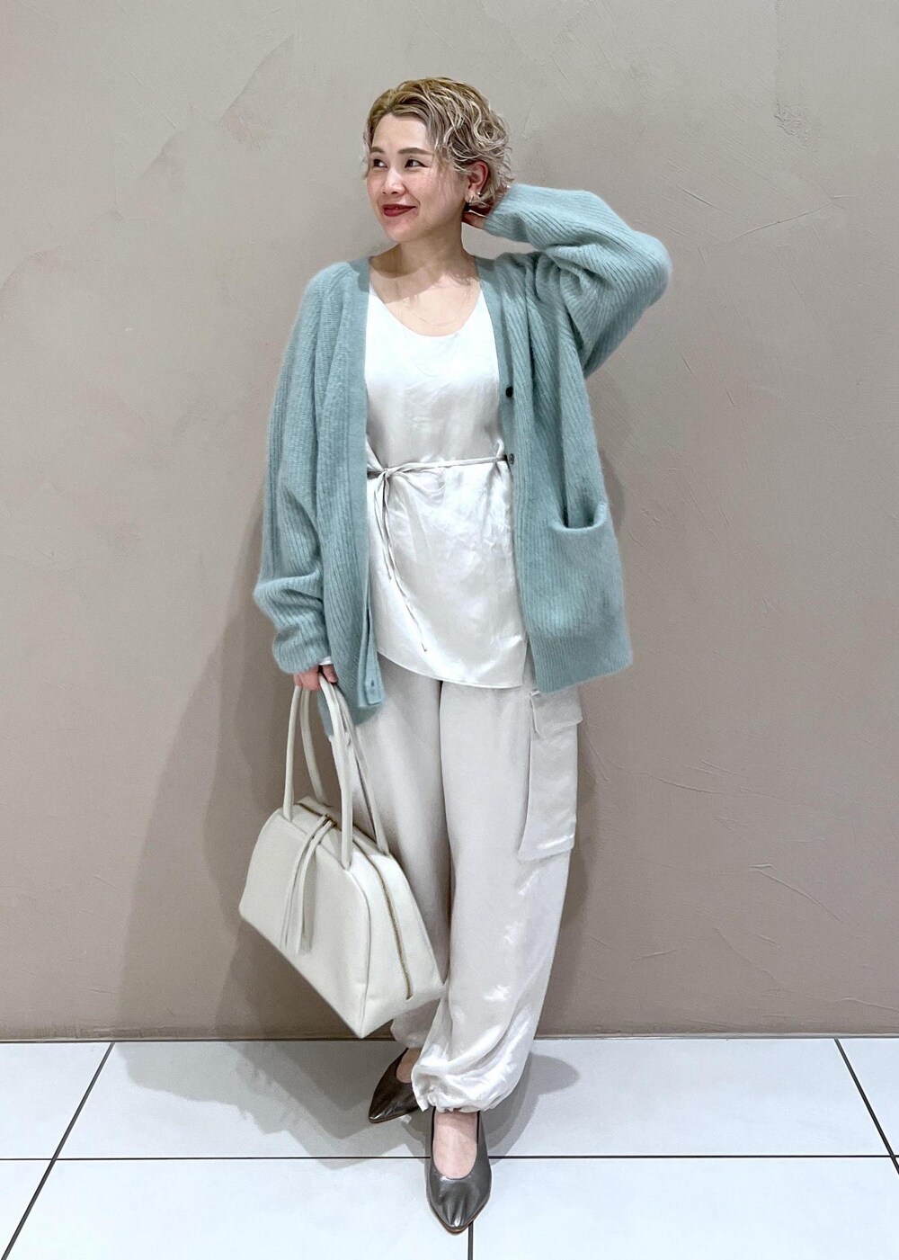 ホワイト系のTシャツ/カットソー、グリーン系のカーディガン/ボレロ、ホワイト系のカーゴパンツを着用したレディースの秋コーディネートの2枚目の写真