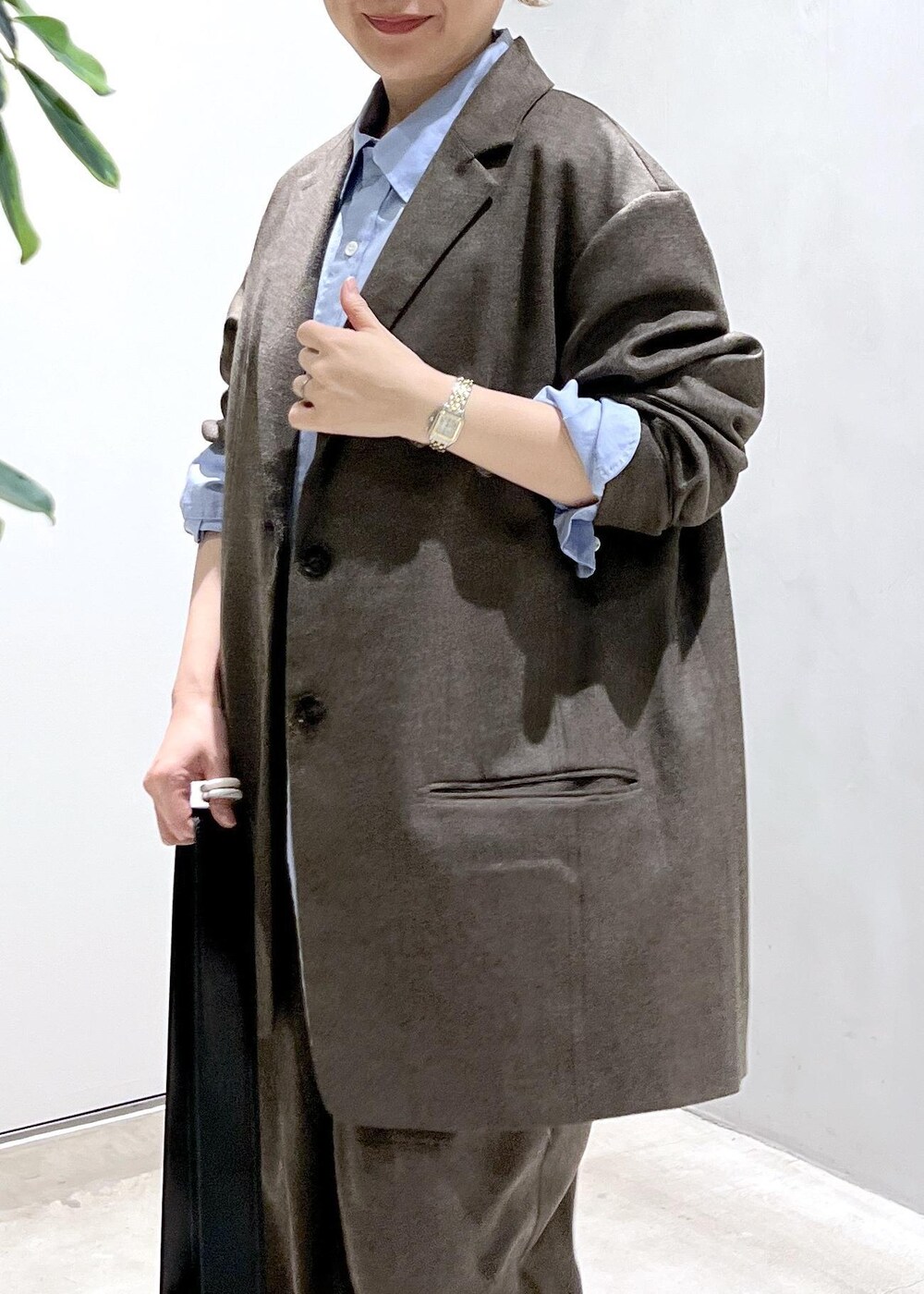 ブルー系のシャツ/ブラウス、ブラック系のショルダーバッグ、ブラウン系のスラックスを着用したレディースの秋コーディネートの7枚目の写真