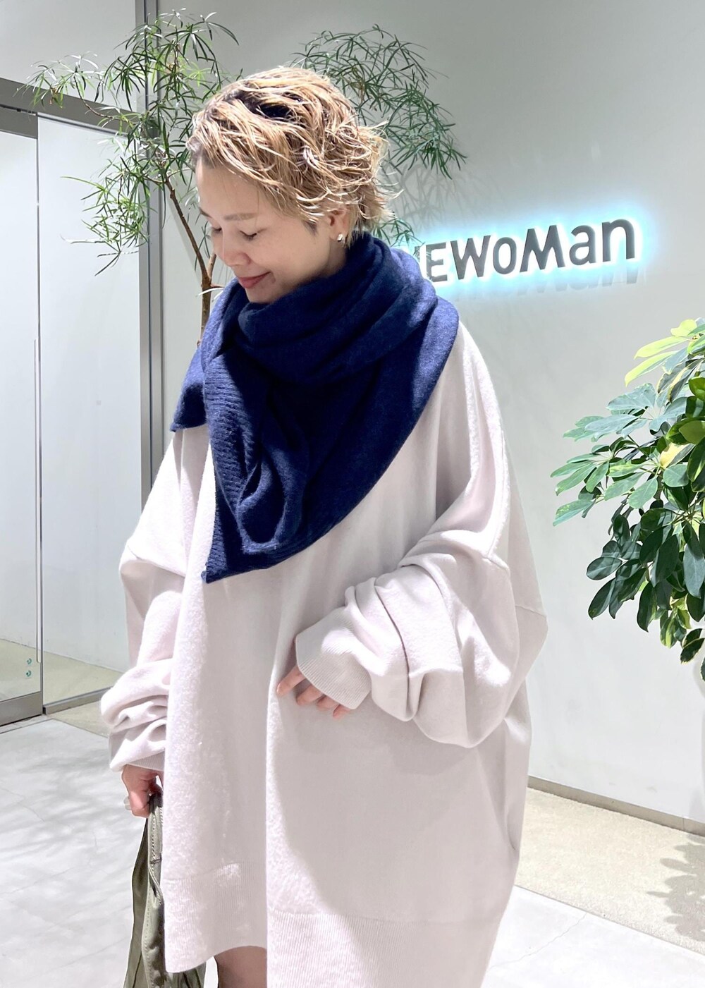 ブラック系のブーツ、グリーン系のトートバッグを着用したレディースの秋コーディネートの4枚目の写真