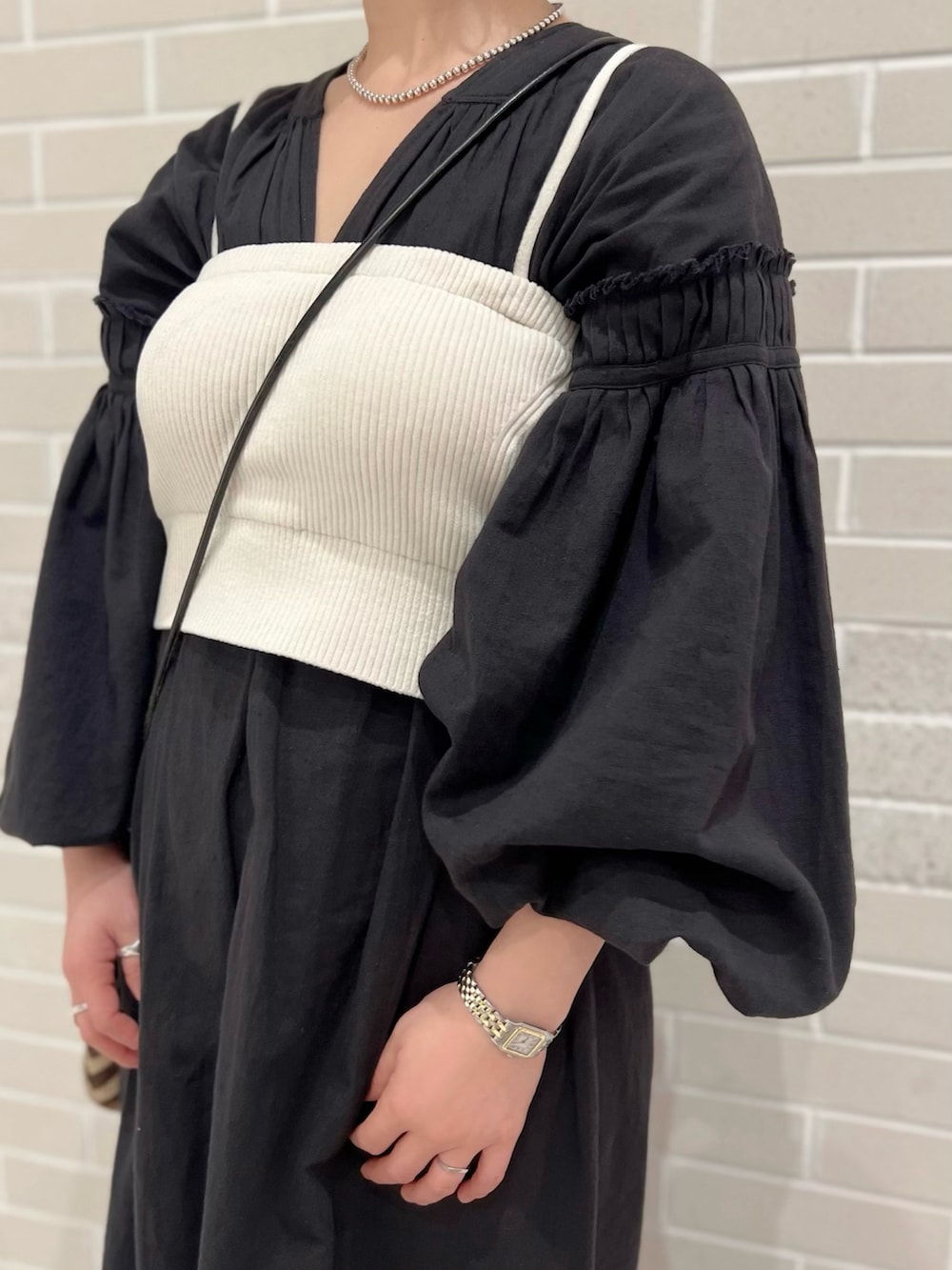 ブラック系のワンピース、ホワイト系のチューブトップ、ベージュ系のワンピースを着用したレディースの春コーディネートの3枚目の写真