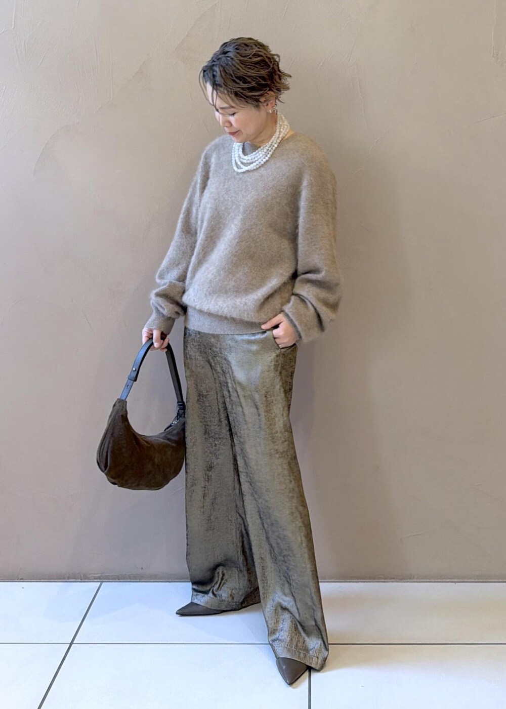 ゴールド系のその他パンツ、ベージュ系のニット/セーター、グリーン系のパンプスを着用したレディースの冬コーディネートの3枚目の写真