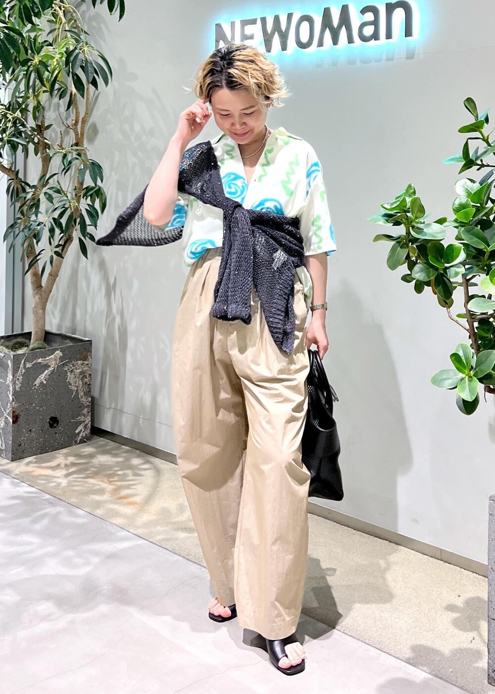 ブラック系のトートバッグ、ブラック系のサンダル、グレー系のカーディガン/ボレロを着用したレディースの春コーディネートの2枚目の写真