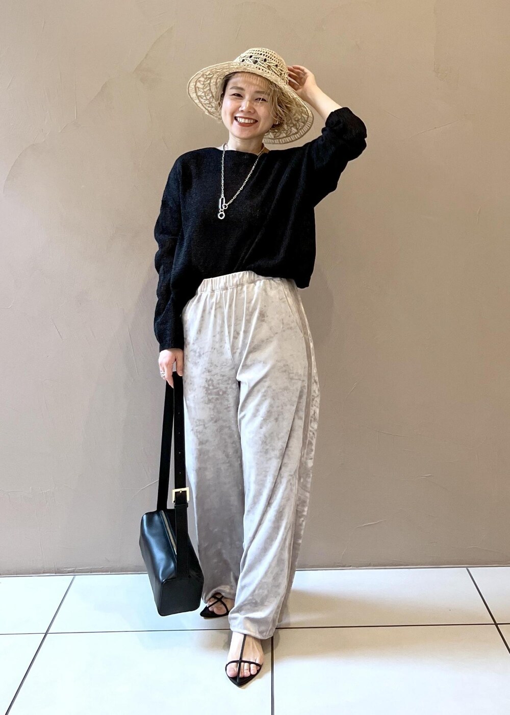 ベージュ系のその他パンツ、ブラック系のサンダル、ブラック系のニット/セーターを着用したレディースの春コーディネートの2枚目の写真