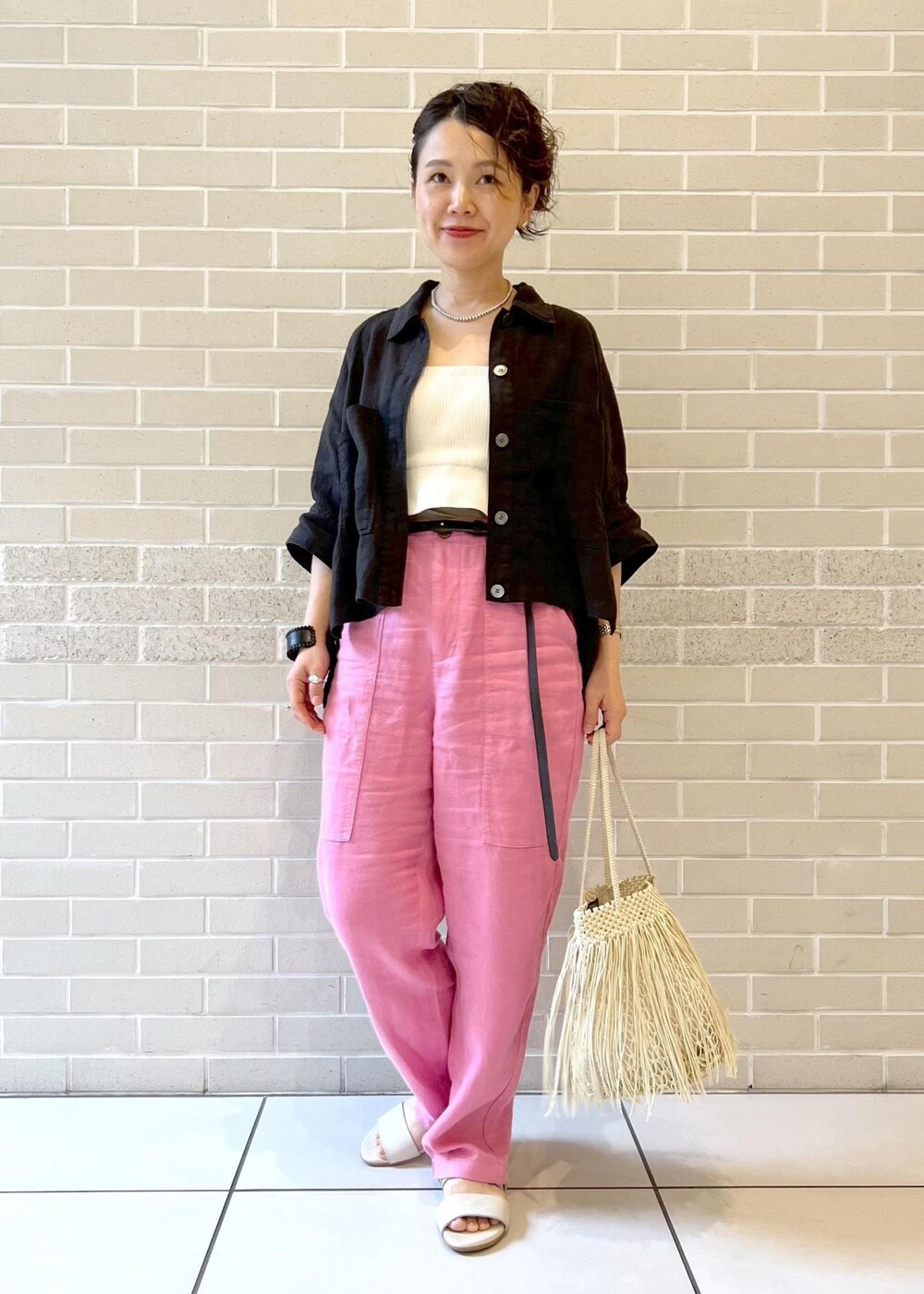 ブラック系のシャツ/ブラウス、ホワイト系のチューブトップ、ベージュ系のサンダルを着用したレディースの春コーディネートの2枚目の写真