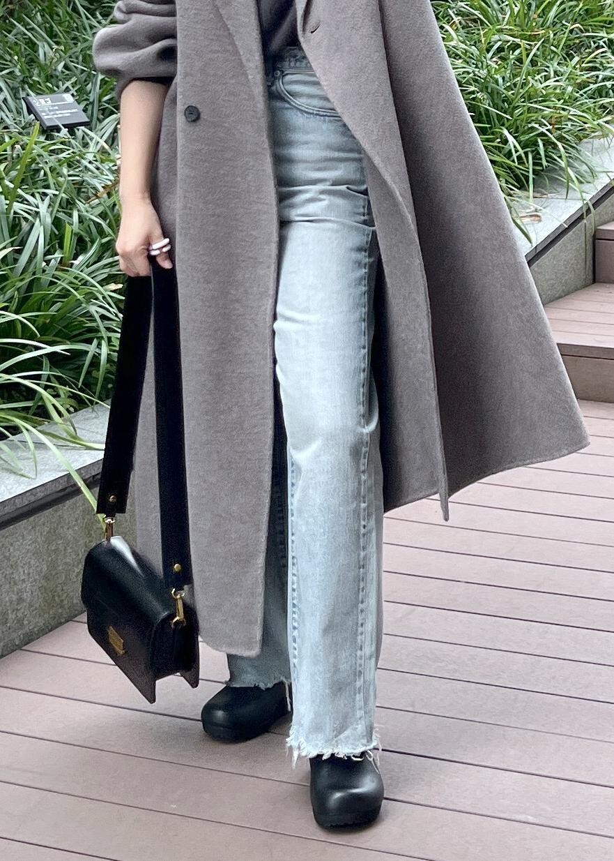 グレー系のニット/セーター、ブラック系のショルダーバッグ、ブラウン系のその他アウターを着用したレディースの秋コーディネートの9枚目の写真