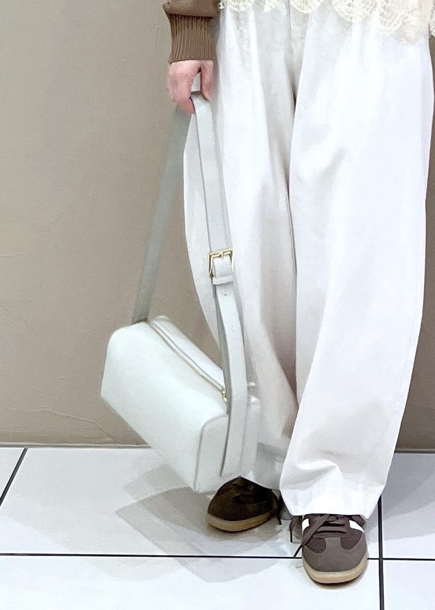 グレー系のショルダーバッグ、ホワイト系のその他パンツ、イエロー系のカーディガン/ボレロを着用したレディースの春コーディネートの6枚目の写真