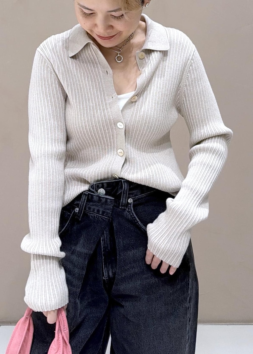 ベージュ系のカーディガン/ボレロ、ピンク系のトートバッグ、ブラック系のデニムパンツを着用したレディースの冬コーディネートの7枚目の写真