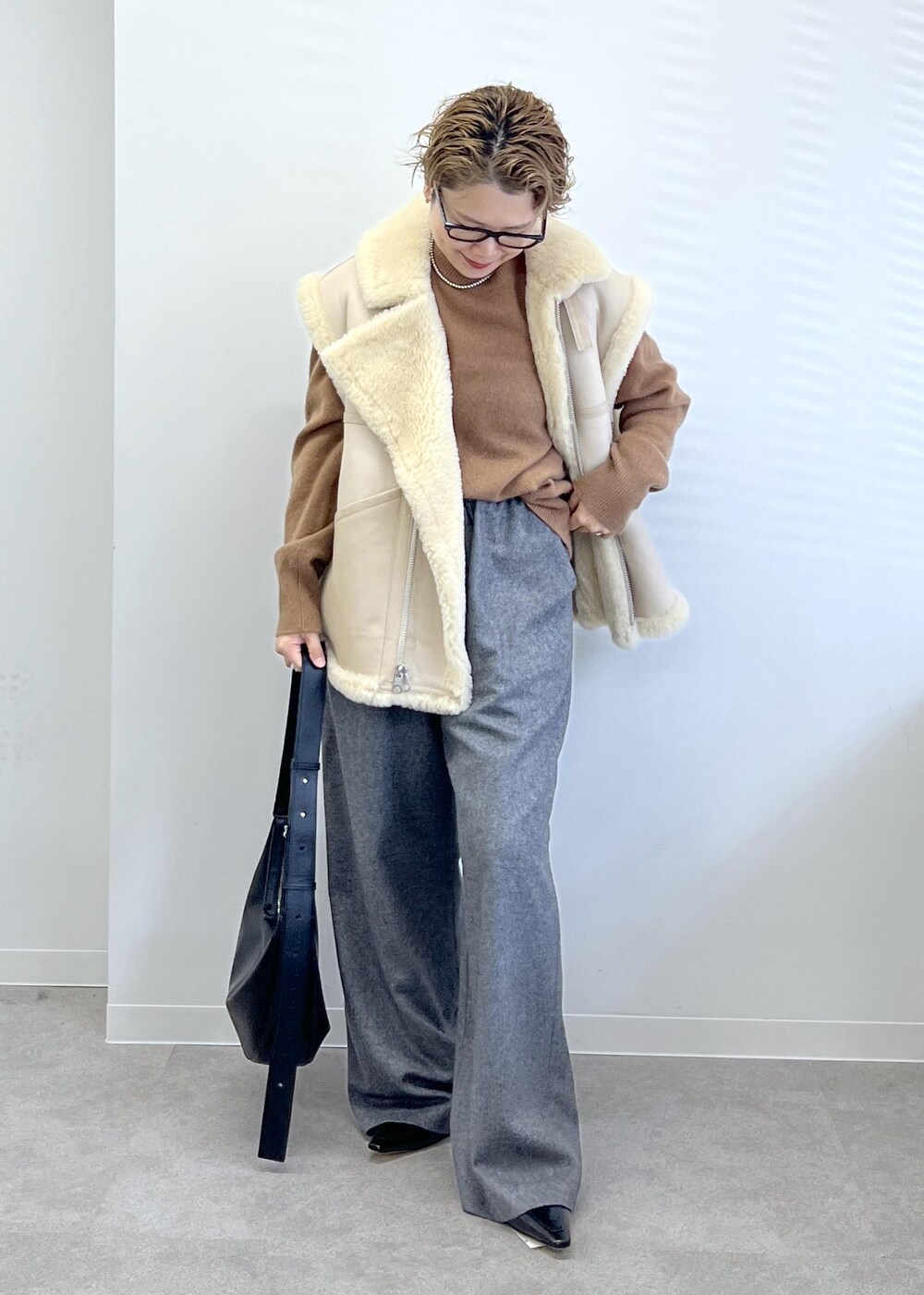 ブラック系のショルダーバッグ、グレー系のその他パンツ、ブラウン系のニット/セーターを着用したレディースの秋コーディネートの4枚目の写真