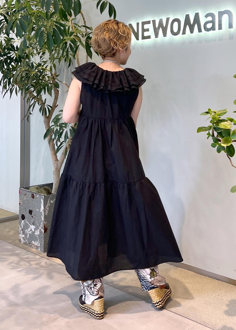 ブラック系のワンピース、ホワイト系のハンドバッグ、ブラック系のサンダルを着用したレディースの夏コーディネートの5枚目の写真