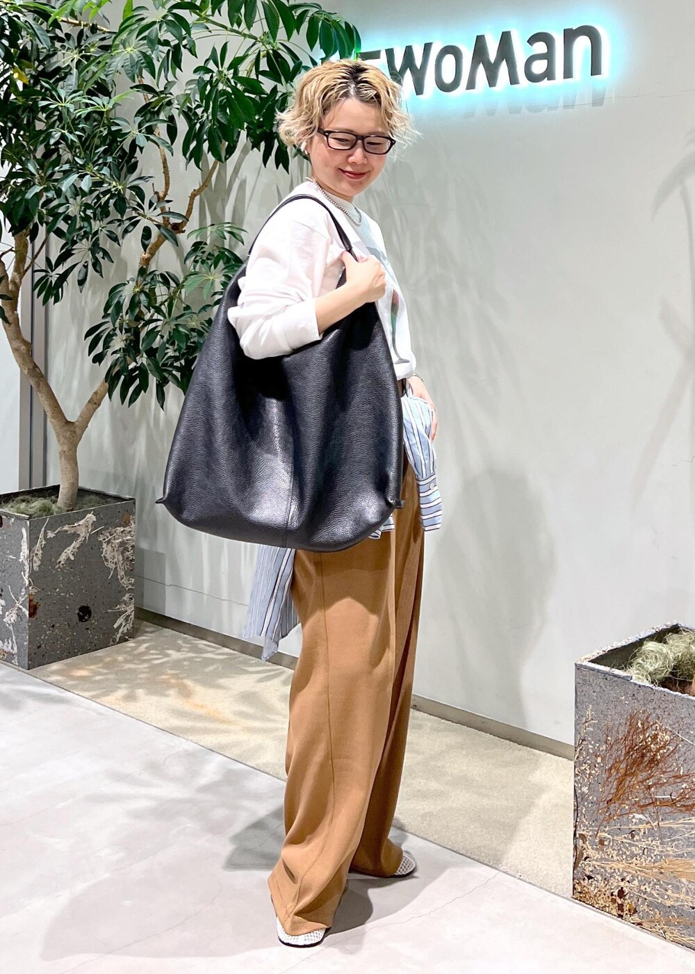 ブラック系のトートバッグ、ブルー系のシャツ/ブラウス、ホワイト系のTシャツ/カットソーを着用したレディースの冬コーディネートの10枚目の写真