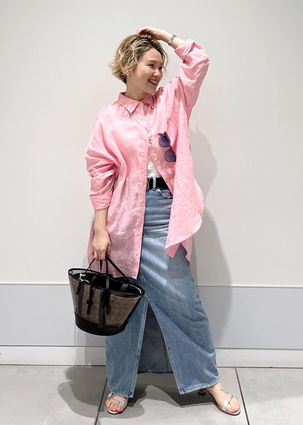 ピンク系のシャツ/ブラウス、ホワイト系のかごバッグ、ブルー系のデニムスカートを着用したレディースの春コーディネートの6枚目の写真