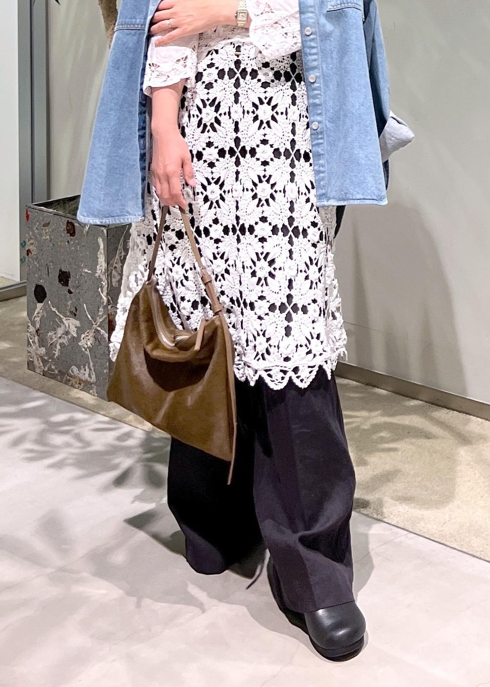 ブラック系のスラックス、ブルー系のシャツ/ブラウス、ブラウン系のショルダーバッグを着用したレディースの夏コーディネートの8枚目の写真