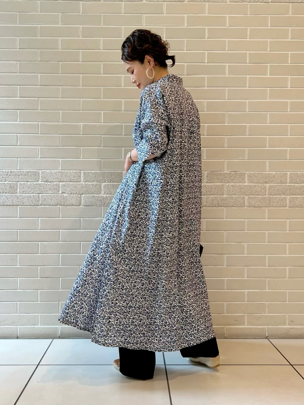 ブルー系のシャツワンピース、ホワイト系のトップス、ブラック系のその他パンツを着用したレディースの春コーディネートの4枚目の写真