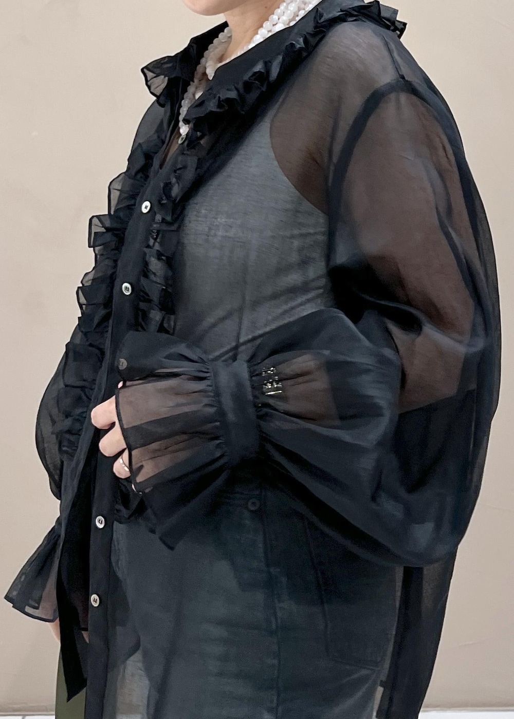 グリーン系のショルダーバッグ、ブルー系のデニムパンツ、ホワイト系のスニーカーを着用したレディースの夏コーディネートの4枚目の写真