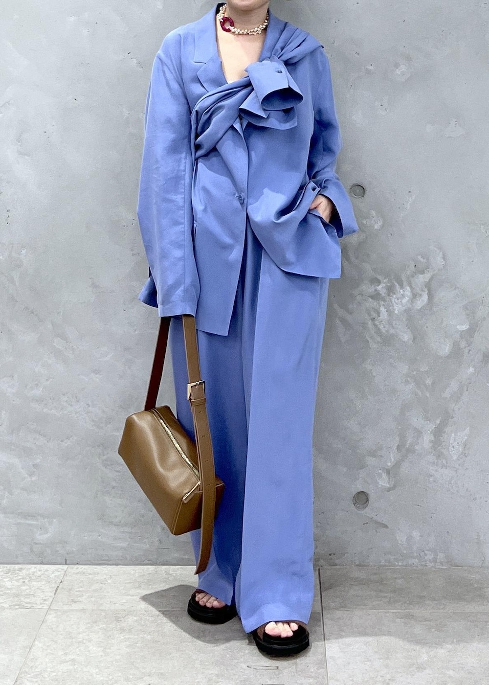 ブラウン系のショルダーバッグ、ブラウン系のサンダル、ブルー系のテーラードジャケットを着用したレディースの冬コーディネートの7枚目の写真