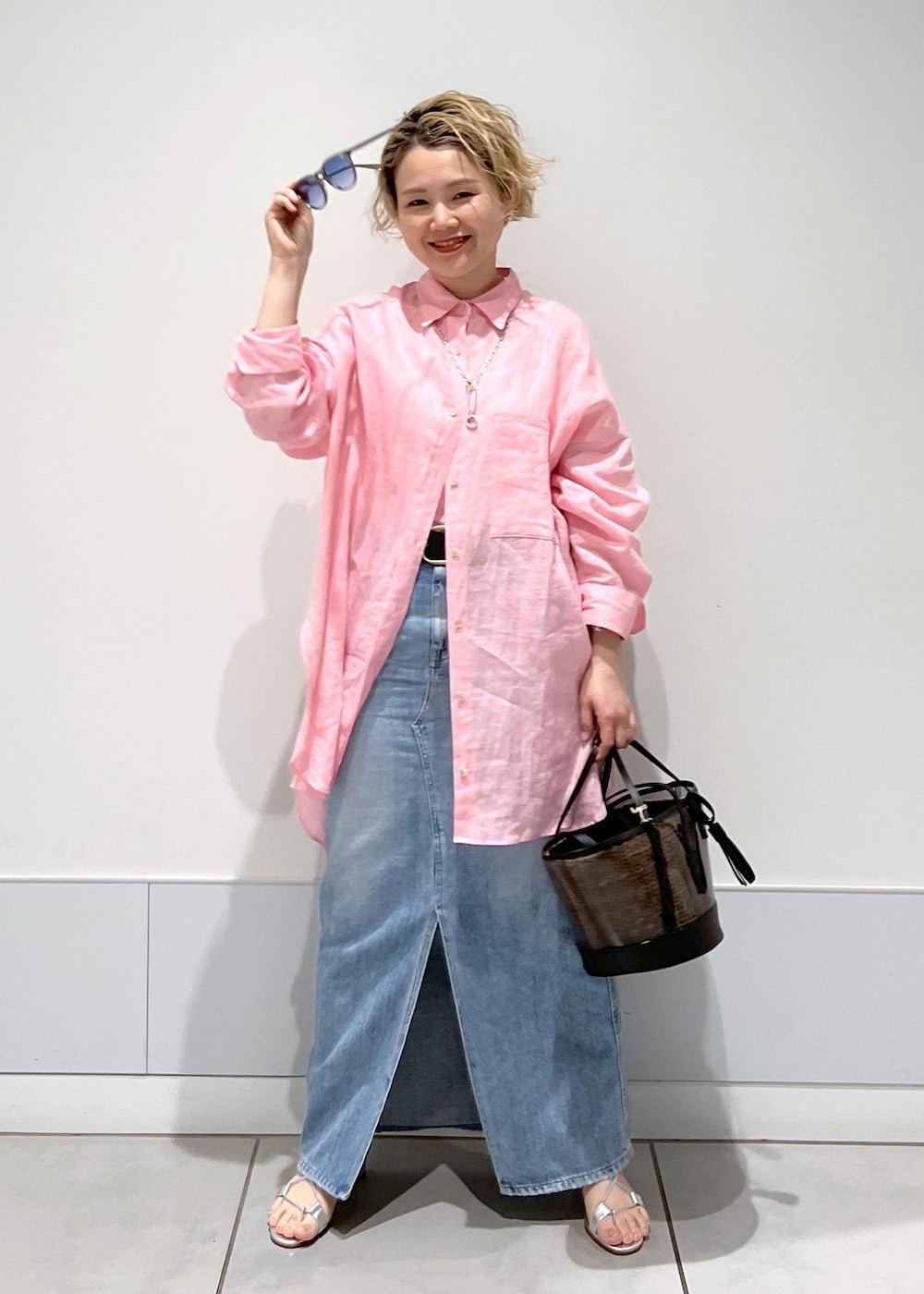 ピンク系のシャツ/ブラウス、ホワイト系のかごバッグ、ブルー系のデニムスカートを着用したレディースの春コーディネートの4枚目の写真