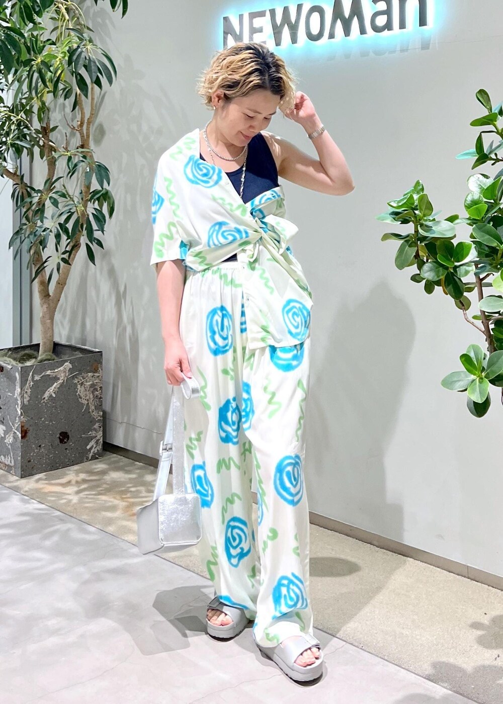 ブルー系のタンクトップ、シルバー系のショルダーバッグ、グレー系のサンダルを着用したレディースの春コーディネートの7枚目の写真