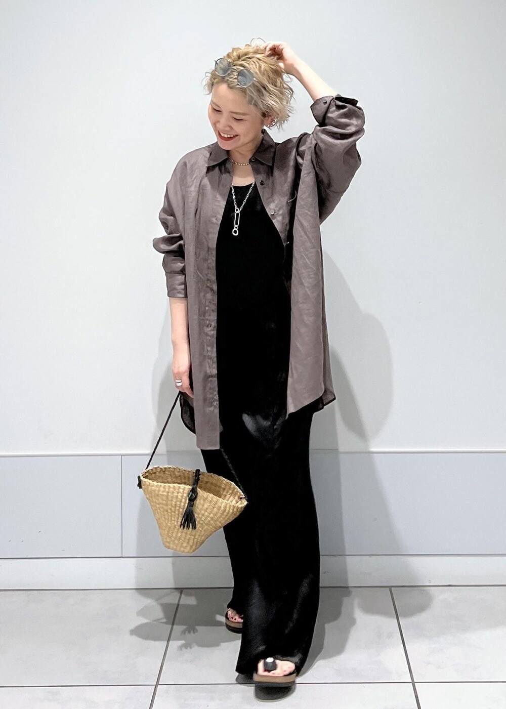 ベージュ系のかごバッグ、グレー系のシャツ/ブラウス、ブラック系のつなぎ/オールインワンを着用したレディースの夏コーディネートの2枚目の写真