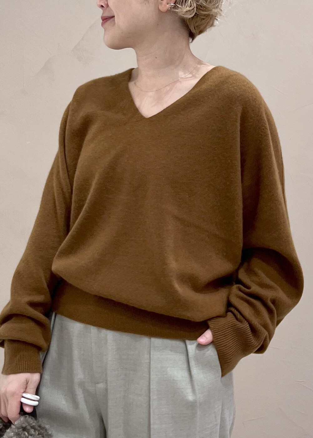 ベージュ系のスラックス、ブラウン系のトートバッグ、イエロー系のニット/セーターを着用したレディースの秋コーディネートの7枚目の写真