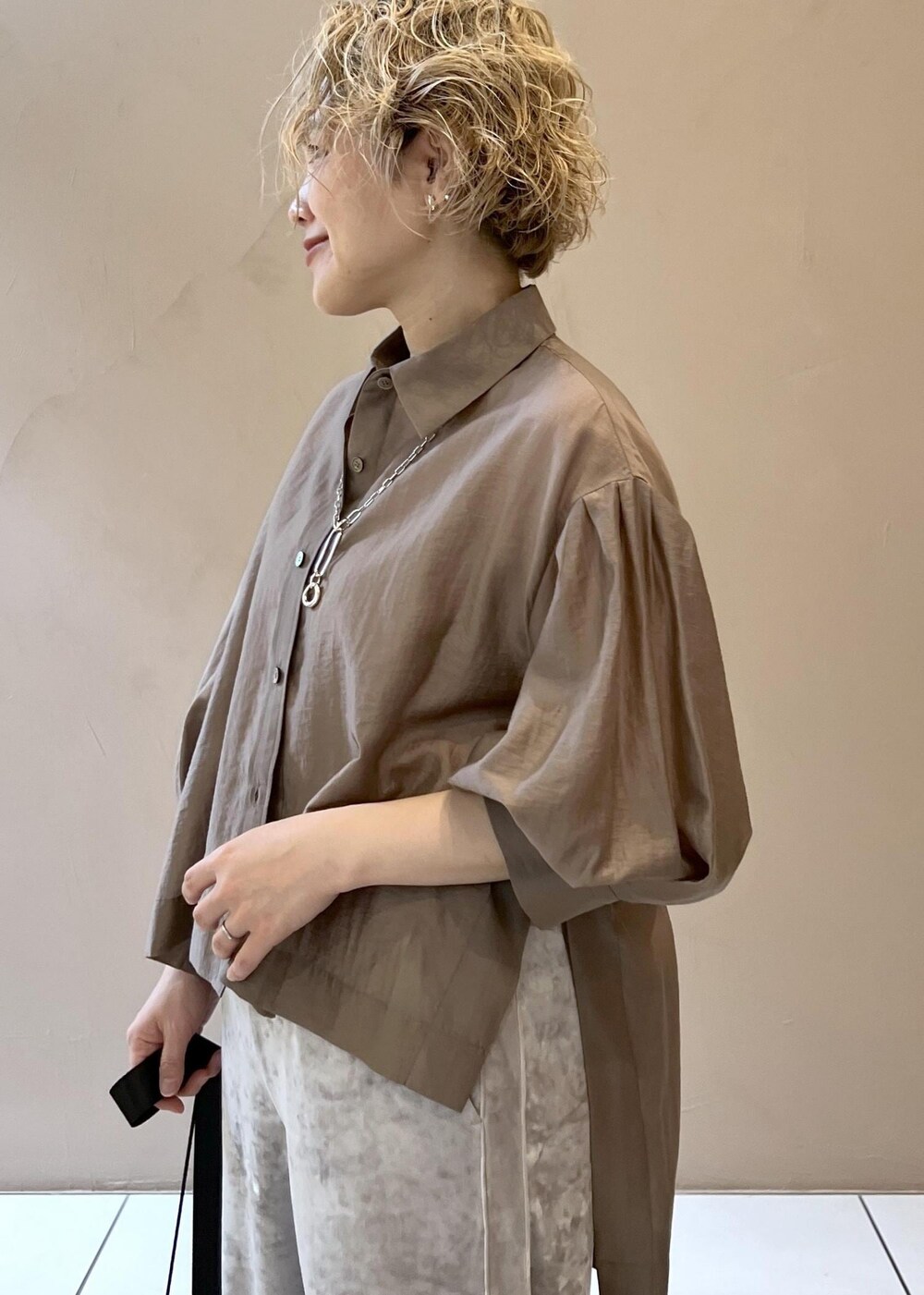 ベージュ系のその他パンツ、ブラック系のサンダル、ブラウン系のシャツ/ブラウスを着用したレディースの春コーディネートの7枚目の写真