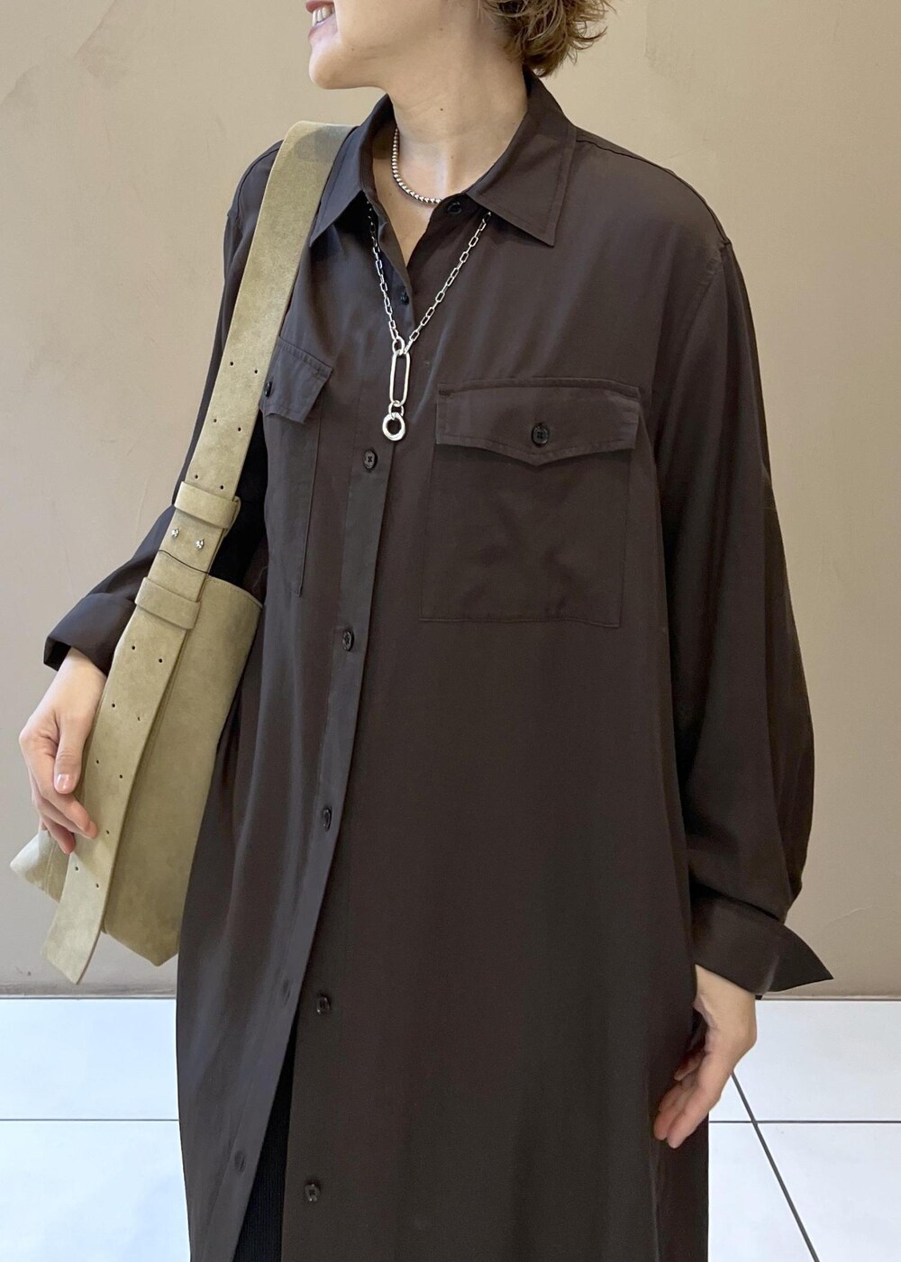 ベージュ系のショルダーバッグ、グレー系のワンピース、ブラック系のブーツを着用したレディースの秋コーディネートの9枚目の写真