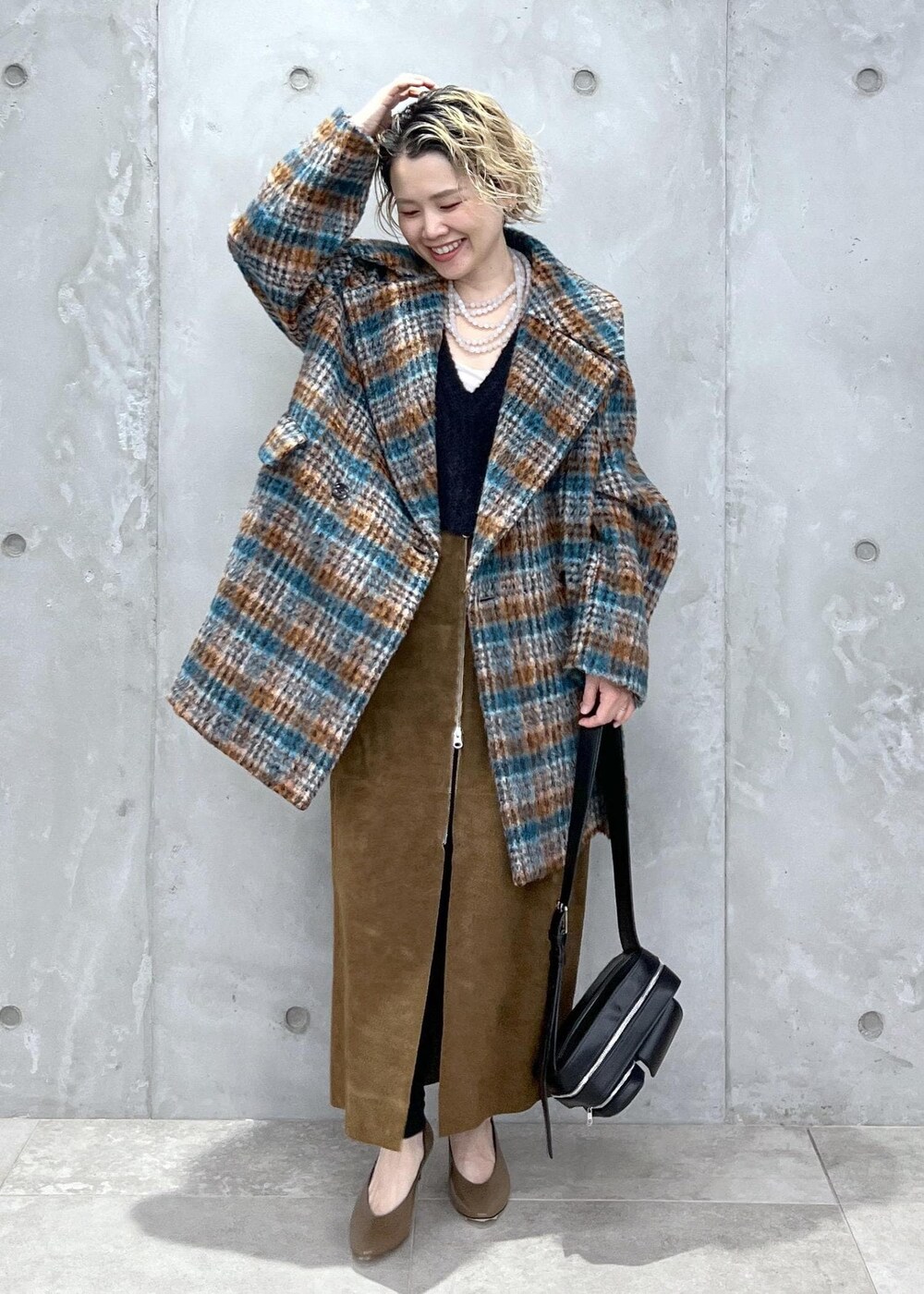 ブラック系のベスト、ブルー系のピーコート、ブラック系のボディバッグ/ウエストポーチを着用したレディースの秋コーディネートの3枚目の写真