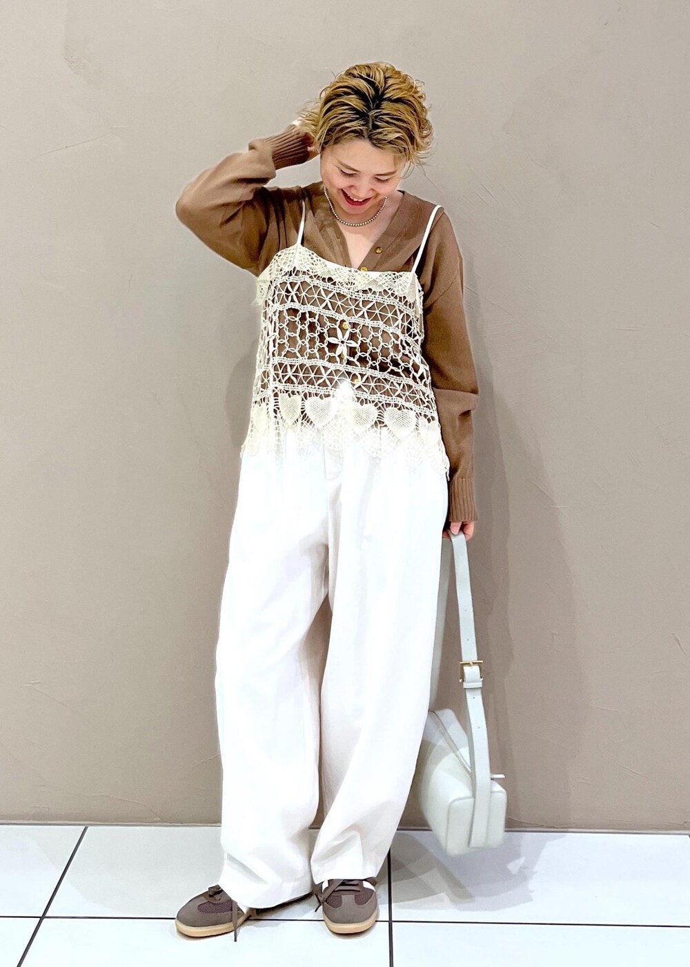 グレー系のショルダーバッグ、ホワイト系のその他パンツ、イエロー系のカーディガン/ボレロを着用したレディースの春コーディネートの4枚目の写真