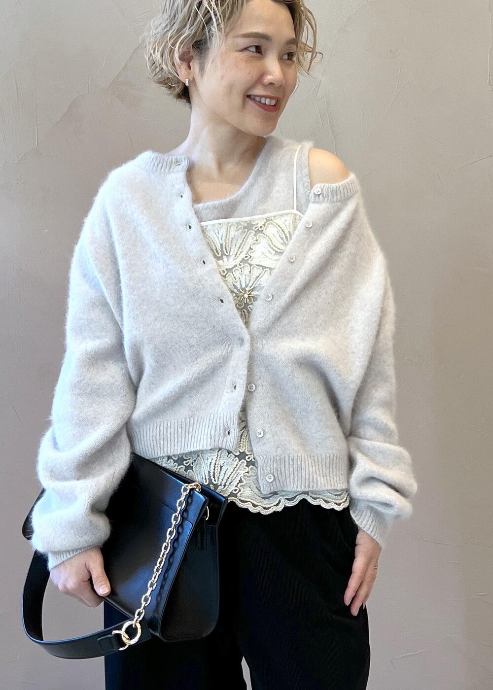 グレー系のタンクトップ、グレー系のカーディガン/ボレロ、ブラック系のショルダーバッグを着用したレディースの冬コーディネートの5枚目の写真