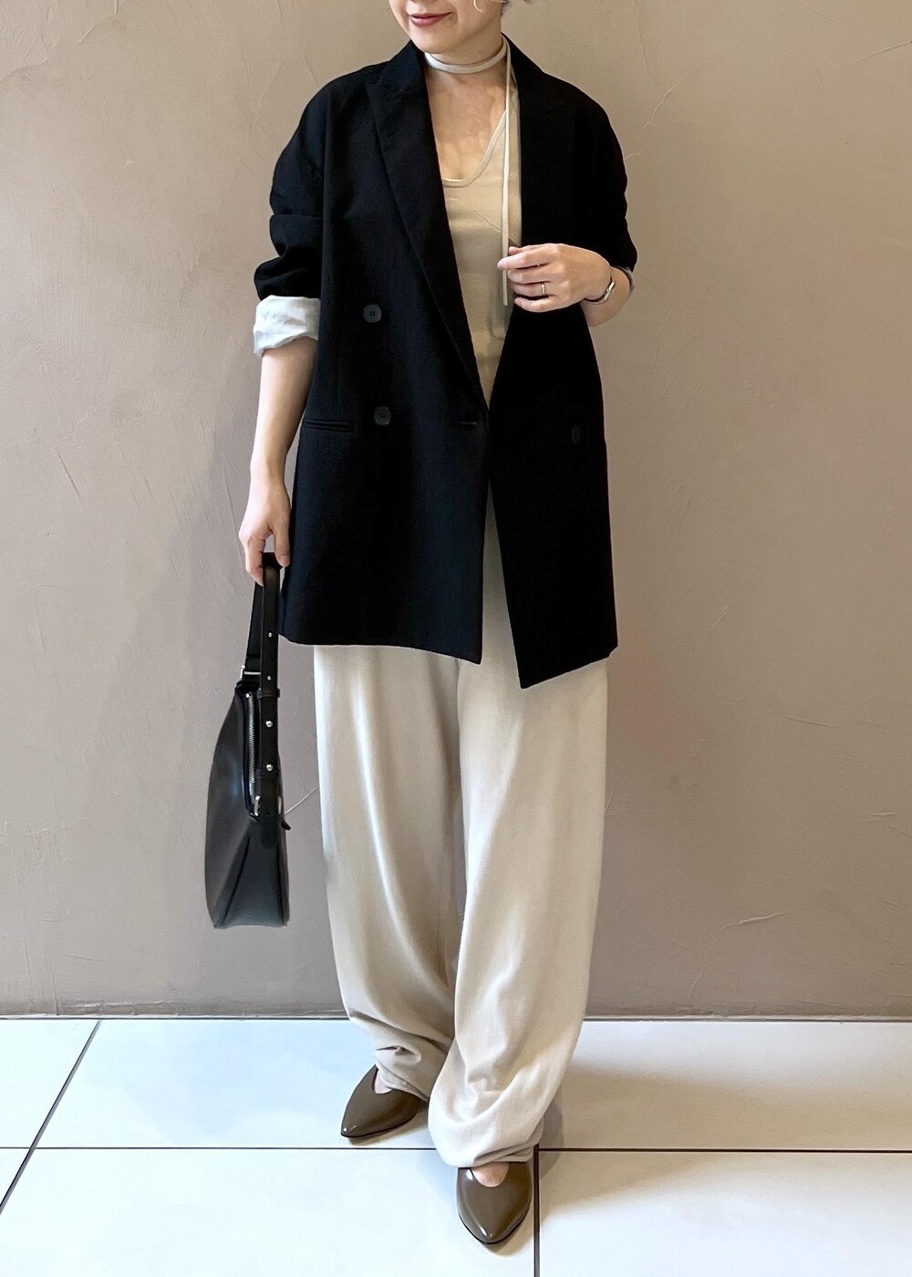 ブラック系のテーラードジャケット、ブラウン系のパンプスを着用したレディースの秋コーディネートの9枚目の写真