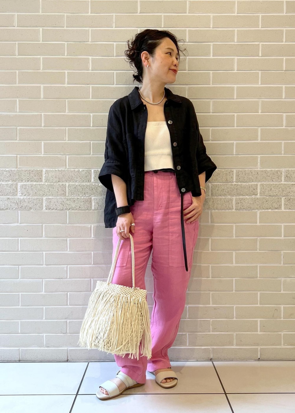 ブラック系のシャツ/ブラウス、ホワイト系のチューブトップ、ベージュ系のサンダルを着用したレディースの春コーディネートの4枚目の写真