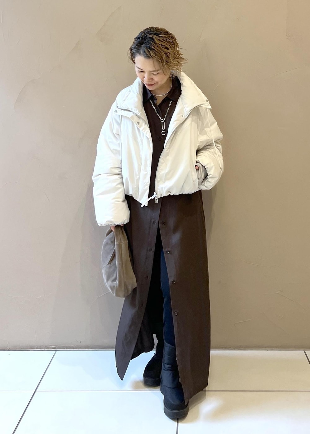 ホワイト系のダウンジャケット/コート、グレー系のハンドバッグ、グレー系のワンピースを着用したレディースの秋コーディネートの3枚目の写真