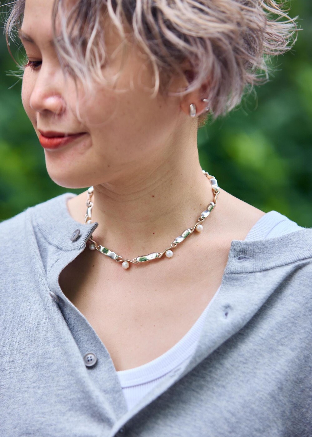 ホワイト系のトートバッグ、シルバー系のサンダルを着用したレディースの夏コーディネートの10枚目の写真