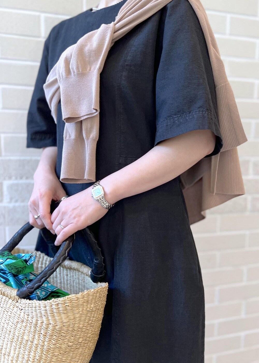 ベージュ系のサンダル、ベージュ系のカーディガン/ボレロ、ブラック系のワンピースを着用したレディースの夏コーディネートの6枚目の写真