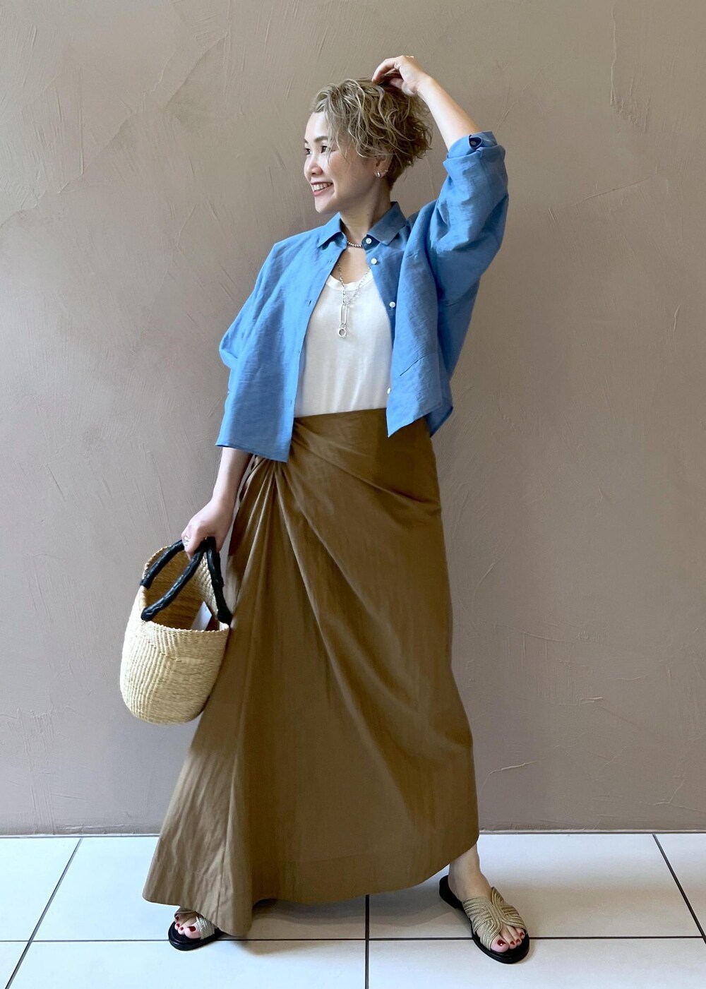 ゴールド系のサンダル、ブラウン系のスカート、ブルー系のシャツ/ブラウスを着用したレディースの夏コーディネートの4枚目の写真