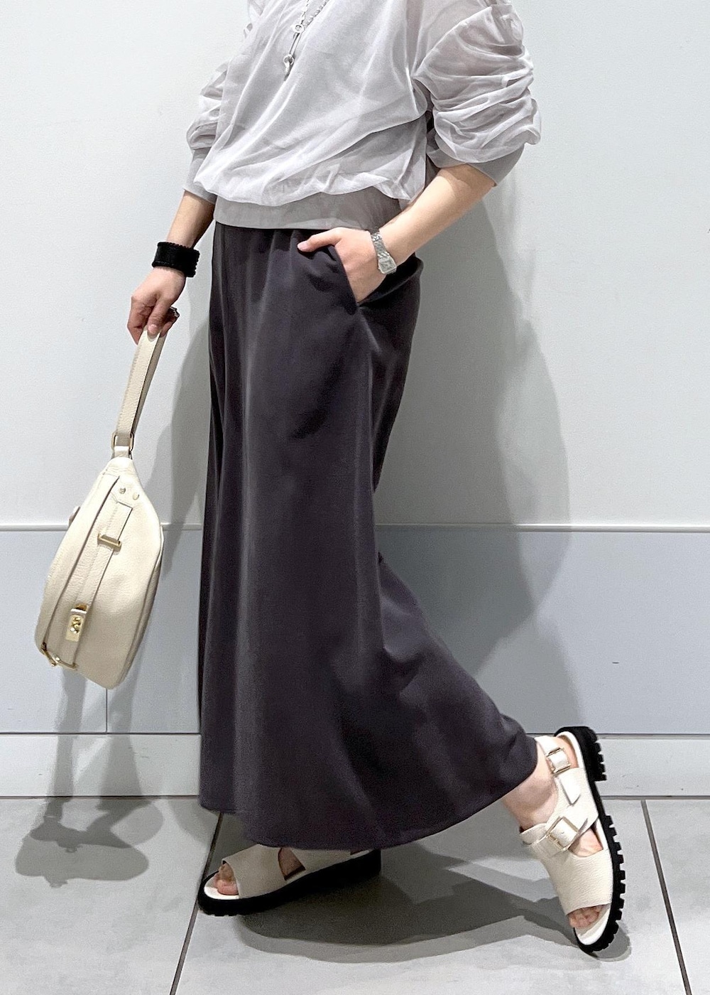 ホワイト系のサンダル、ベージュ系のボディバッグ/ウエストポーチ、グレー系のワンピースを着用したレディースの春コーディネートの4枚目の写真