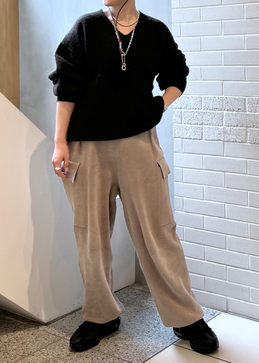 ホワイト系のピーコート、グレー系のカーゴパンツ、ブラウン系のニット/セーターを着用したレディースの秋コーディネートの9枚目の写真