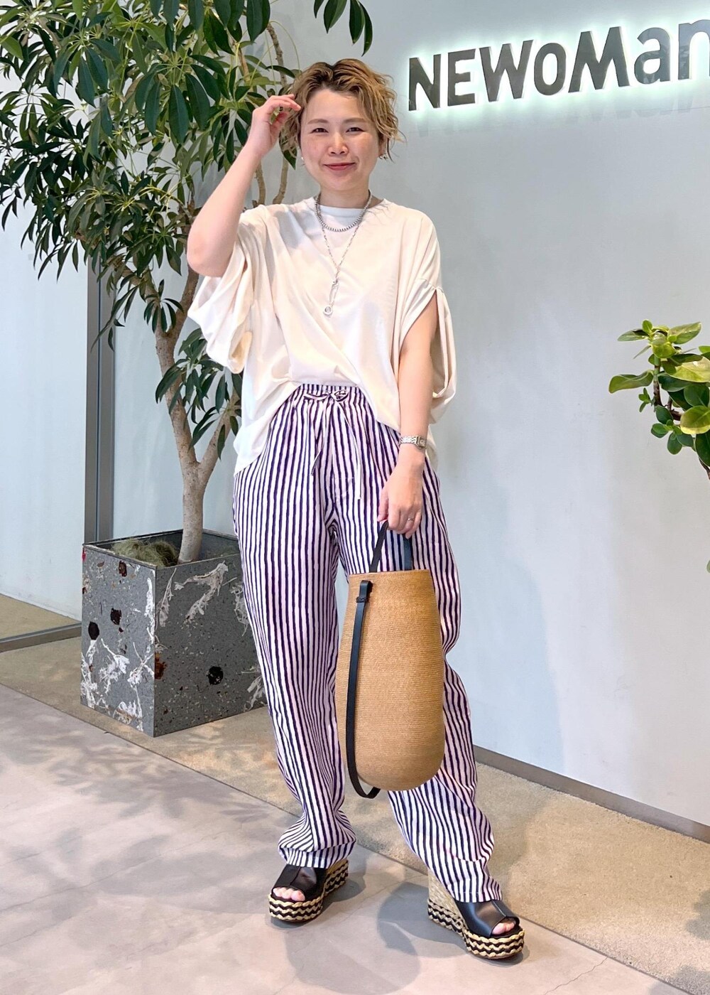 ホワイト系のTシャツ/カットソー、ベージュ系のショルダーバッグ、ブラック系のサンダルを着用したレディースの夏コーディネートの3枚目の写真