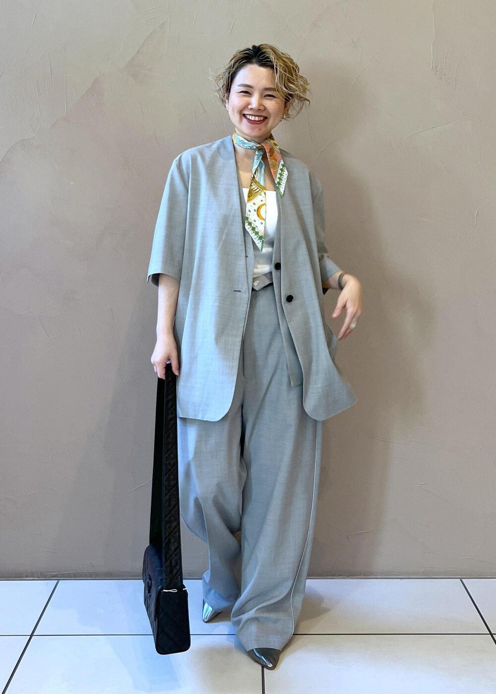 グレー系のベスト、グレー系のスラックス、グレー系のテーラードジャケットを着用したレディースの冬コーディネートの4枚目の写真