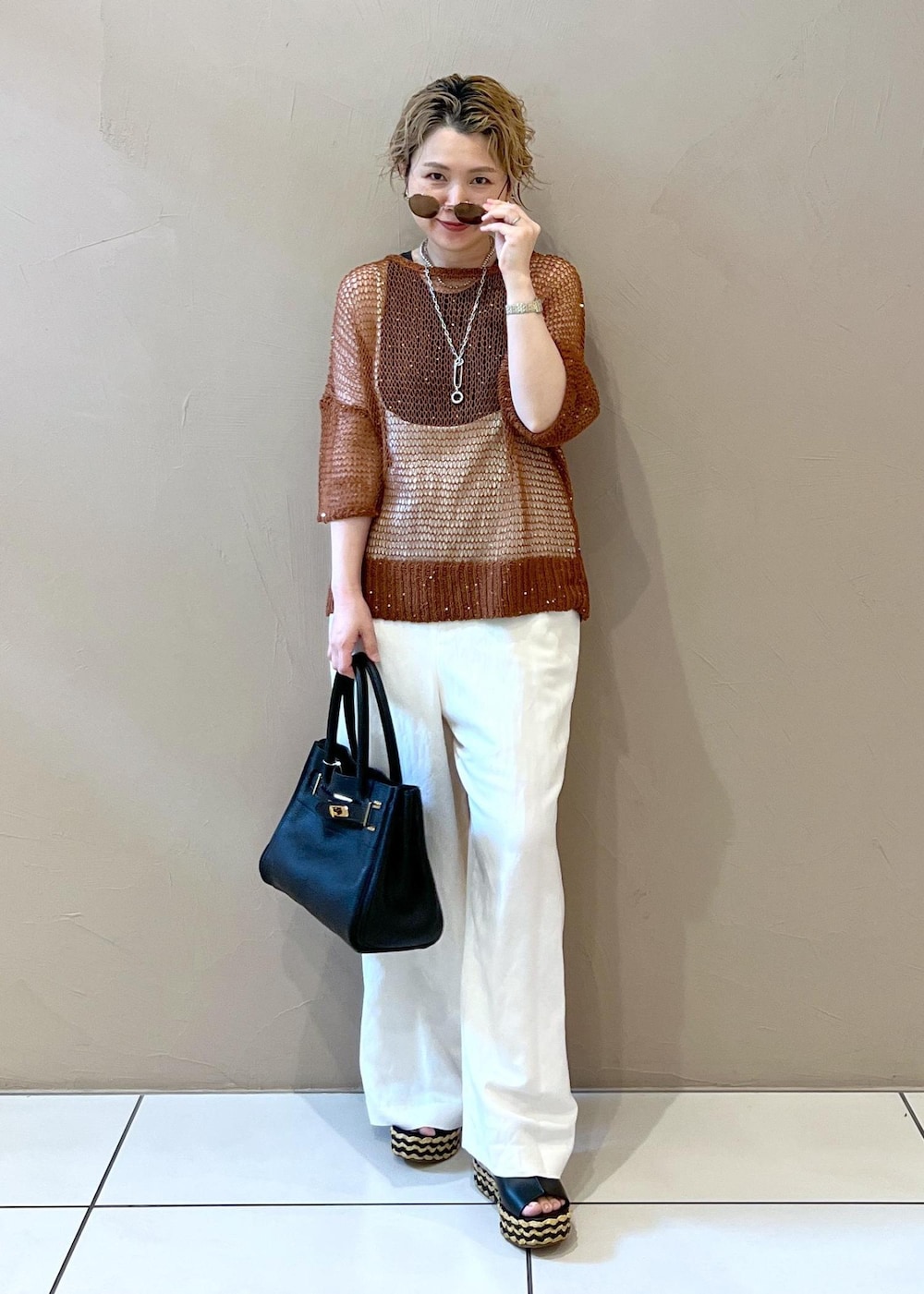 ホワイト系のサロペット/オーバーオール、グレー系のタンクトップ、ブラック系のショルダーバッグを着用したレディースの夏コーディネートの3枚目の写真