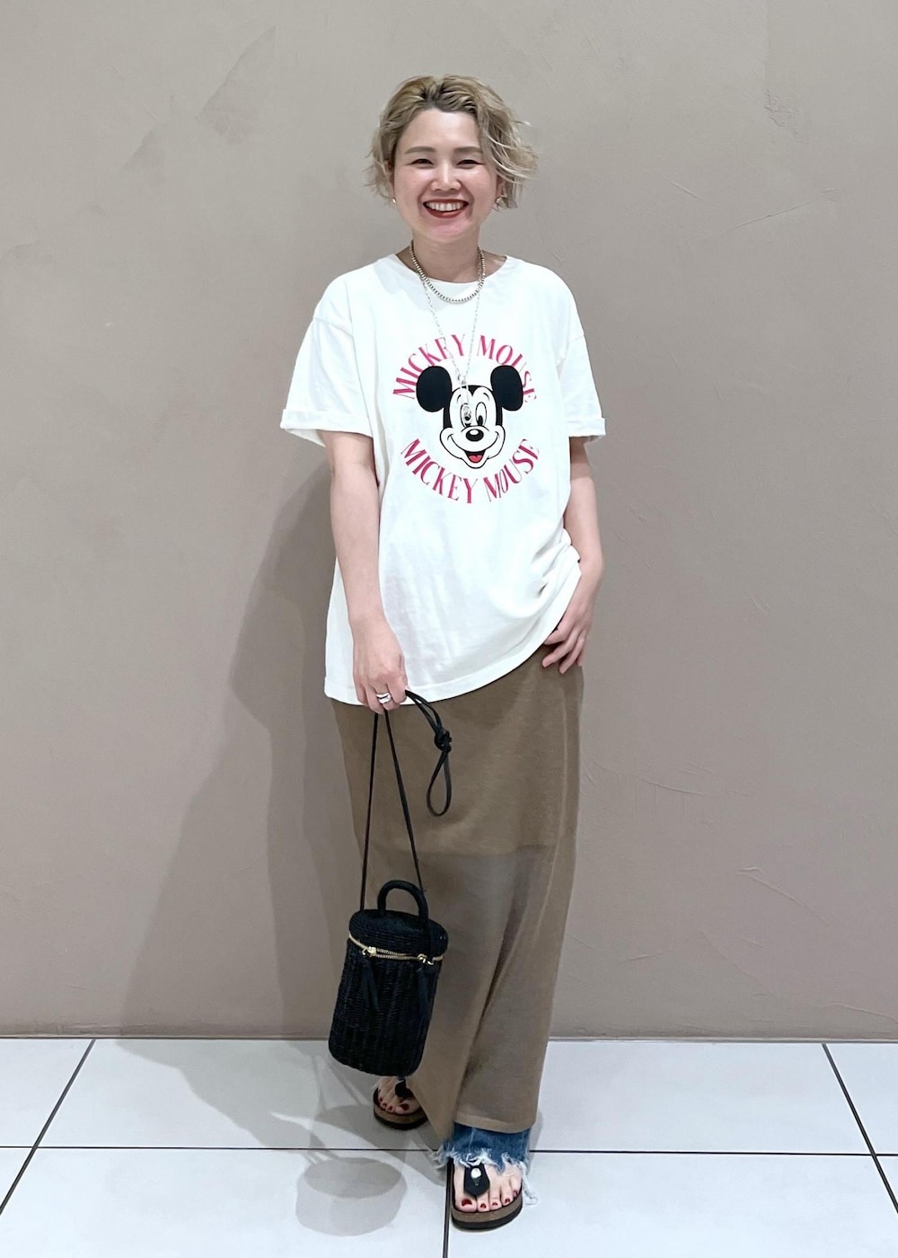 ブラック系のショルダーバッグ、ホワイト系のTシャツ/カットソー、ブルー系のデニムパンツを着用したレディースの夏コーディネートの4枚目の写真