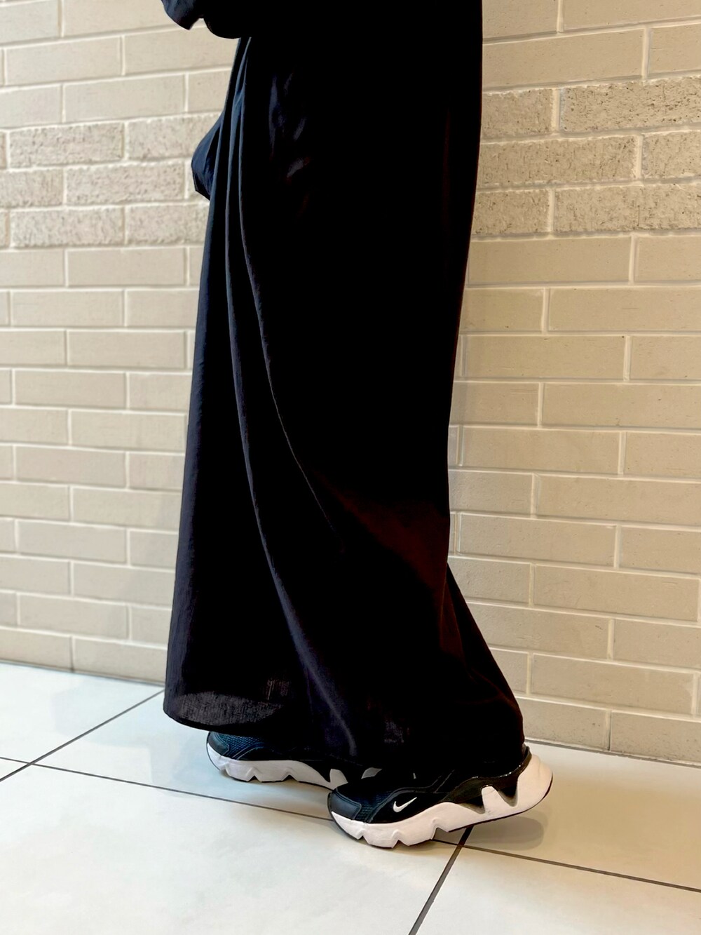 ブラック系のワンピース、ベージュ系のワンピース、ブラック系のスニーカーを着用したレディースの春コーディネートの5枚目の写真