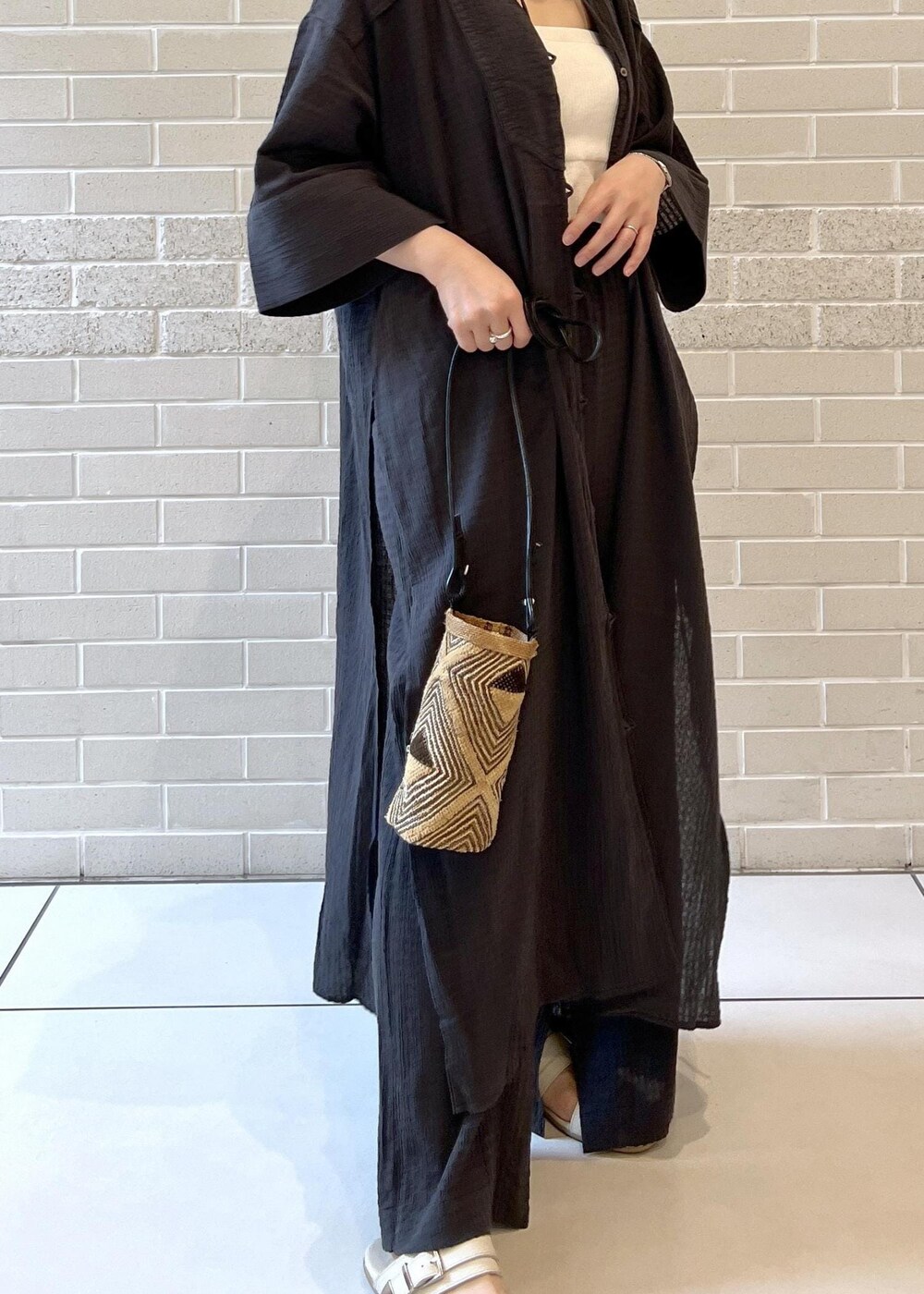 ホワイト系のチューブトップ、ベージュ系のサンダル、ブラック系のシャツ/ブラウスを着用したレディースの夏コーディネートの8枚目の写真