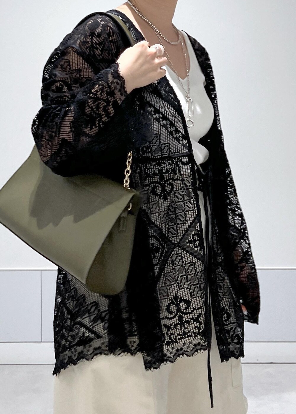 ホワイト系のカーゴパンツ、ホワイト系のキャミソール、ブラック系のノーカラージャケットを着用したレディースの夏コーディネートの8枚目の写真