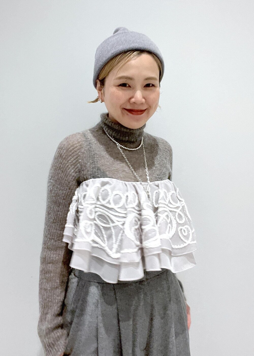 ブラック系のブーツ、グレー系のニット/セーター、ベージュ系のストール/ショールを着用したレディースの冬コーディネートの7枚目の写真