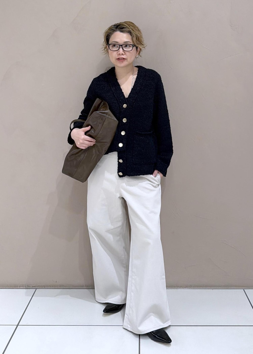 ブラック系のカーディガン/ボレロ、ホワイト系のサロペット/オーバーオール、ブラック系のローファーを着用したレディースの冬コーディネートの3枚目の写真