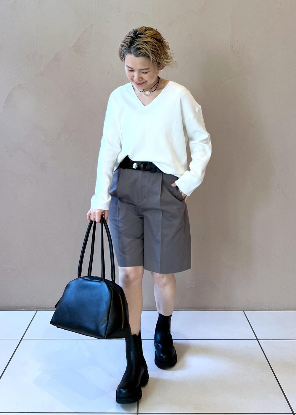 ブラック系のブーツ、ホワイト系のニット/セーター、グレー系のその他パンツを着用したレディースの冬コーディネートの2枚目の写真