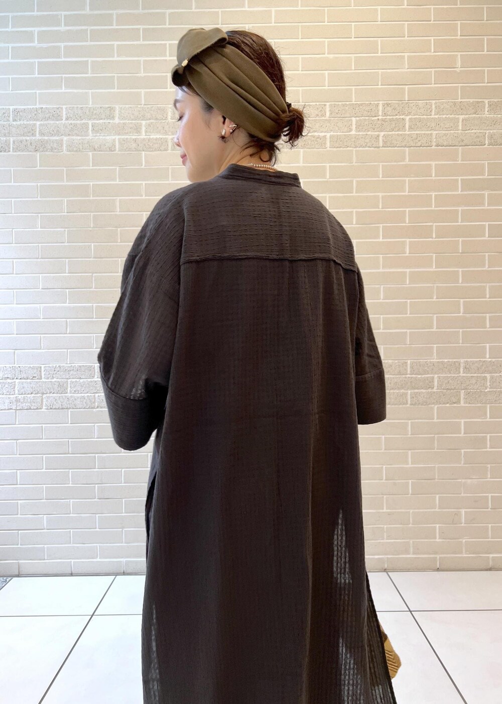 ホワイト系のチューブトップ、ベージュ系のサンダル、ブラック系のシャツ/ブラウスを着用したレディースの夏コーディネートの9枚目の写真