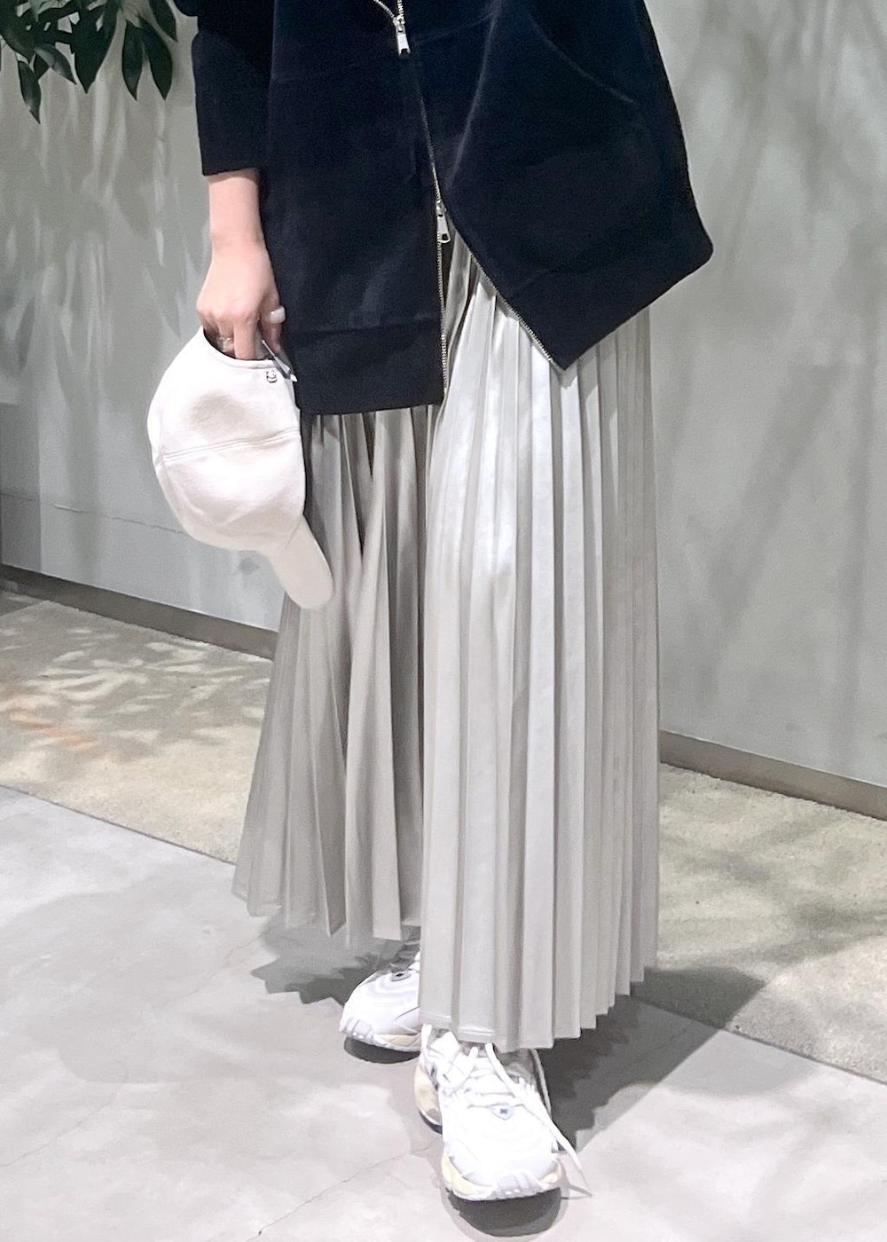 ベージュ系のスカート、ブラック系のタンクトップ、ブラック系のパーカーを着用したレディースの秋コーディネートの9枚目の写真